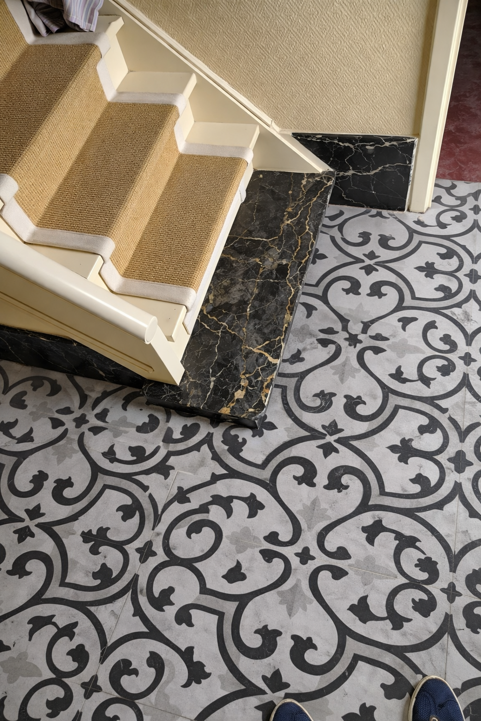 Ornate tile flooring on stairway landing.png